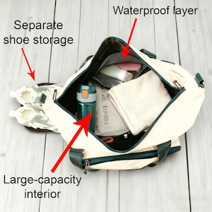 May include: Cream-coloured duffel bag with a large-capacity interior, separate shoe storage, and a waterproof layer. The bag has dark green accents and a dark green handle. Inside the bag is a water bottle, towel, and toiletries.