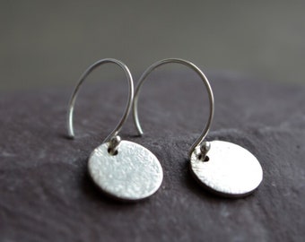 Sterling silver disc charm hoop earrings.