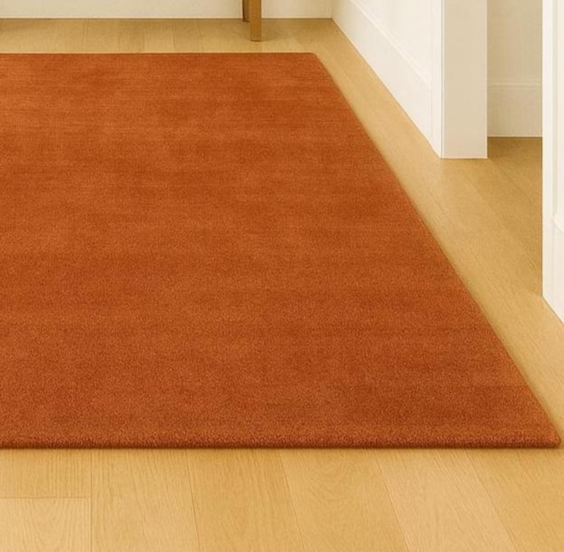 Earthy warm tone rug adding color to neutral Scandinavian bedroom