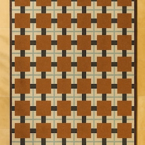 May include: A rectangular area rug with a repeating pattern of brown squares and black cross shapes on a beige background. The rug has a dark brown border and is placed on a light brown tiled floor.