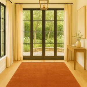 Soft hand-tufted terracotta rug styled in cozy bedroom