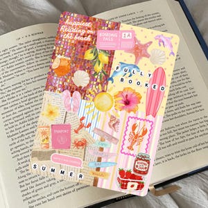 May include: A rectangular bookmark featuring a collage of summer-themed illustrations including lemons, a surfboard, a lobster, strawberries, and text that reads "happiest reading on the beach," "boarding pass 1A," "fully booked," and "summer."