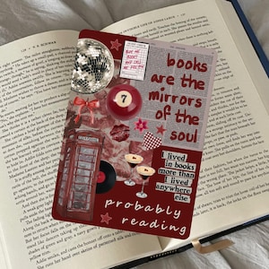 Op de afbeelding: Een decoratieve bladwijzer met de tekst "books are the mirrors of the soul" en andere tekst, samen met een discobal, een biljartbal en een telefooncel-illustratie, op een open boek.