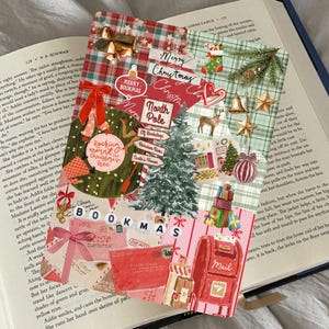 Può includere: Una collezione di segnalibri a tema natalizio con disegni festivi. I segnalibri presentano immagini natalizie come alberi di Natale, renne e scatole regalo, con il testo "Merry Christmas" e "Bookmas". I segnalibri sono posizionati su un libro aperto.