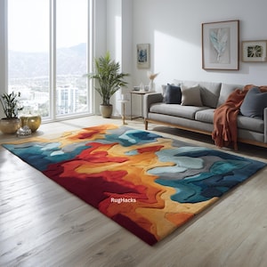 Könnte beinhalten: Ein großer, rechteckiger Teppich mit einem abstrakten Design in leuchtenden Farben. Der Teppich zeigt ein Farbspiel aus Rot, Orange, Gelb, Blau und Grau, das einen topografischen Effekt erzeugt. Er liegt auf einem hellen Holzboden.