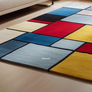 May include: A rectangular area rug with a geometric design. The rug features a patchwork of various colors, including red, blue, yellow, black, and cream, separated by black lines. The rug is placed on a light-colored wooden floor.