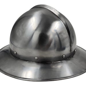 Pode incluir: Um capacete de metal polido prateado, com aba larga e coroa arredondada. O capacete tem uma superfície lisa e refletora e é rebitado ao redor da aba. O design lembra uma armadura histórica.