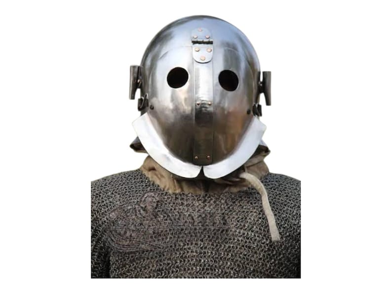 May include: A shiny silver metal helmet with two eye holes and a hinged visor. The helmet features a neck guard and is worn over a chainmail shirt. The background is plain white.