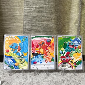 May include: Three Pokémon trading cards featuring Squirtle, Charmander, and Bulbasaur. Each card displays the character with 80 HP, colorful graphic backgrounds, and small Pikachu silhouettes. The cards are displayed upright in clear plastic sleeves.
