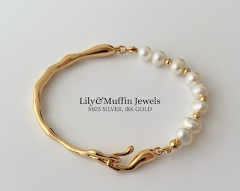 Puede incluir: Una pulsera dorada con un diseño orgánico único. La pulsera presenta perlas blancas y pequeñas cuentas doradas. El texto "Lily & Muffin Jewels S925 SILVER, 18K GOLD" es visible.