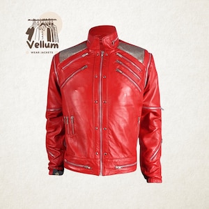 May include: A vibrant red leather jacket with silver zippers and accents. The jacket features a stand-up collar, multiple zippered pockets, and silver shoulder detailing. The jacket is from Vellum Wear Jackets.