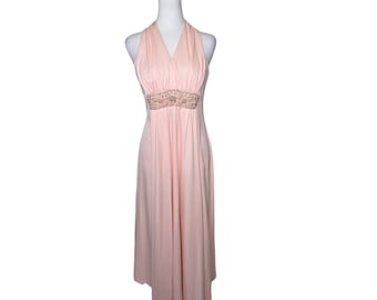 May include: A peach-colored halter dress with a beaded embellishment at the waist.