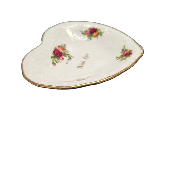 May include: Heart-shaped, off-white porcelain dish with a gold rim. The dish is decorated with clusters of pink and red roses. The words "With love" are printed on the dish.
