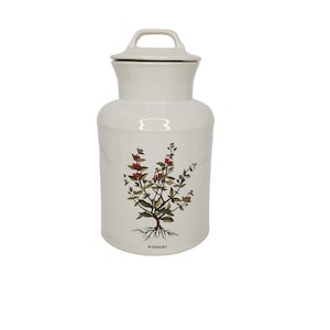 Puede incluir: Tarro de cerámica blanco con tapa y un diseño floral de romero. El tarro está etiquetado como "Romero".