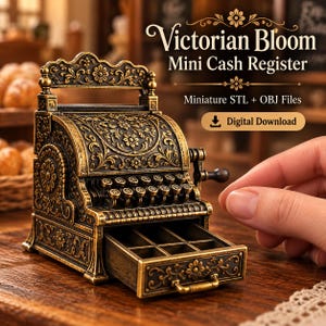 Puede incluir: Una caja registradora en miniatura con un acabado metálico oscuro ornamentado y detalles florales en tono dorado. El dispositivo cuenta con una fila de teclas circulares, un cajón extraíble con seis compartimentos y el texto Victorian Bloom Mini Cash Register.