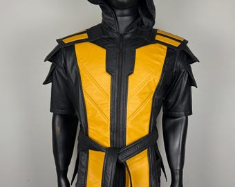 May include: Black and yellow hooded vest with a matching belt. The vest features a zip-up front and shoulder accents. The yellow panels are outlined in black. The mannequin is wearing black pants.
