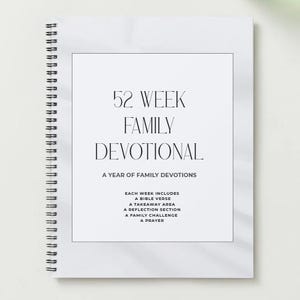 Peut inclure: Un cahier à spirales blanc avec le titre "52 Week Family Devotional" en texte noir. Le cahier comprend des sections pour les versets bibliques, la réflexion et la prière. La couverture a un design minimaliste.