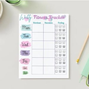 May include: A white fitness tracker notepad with the text "Wubly Fitness Tracker". The notepad has sections for workout, duration, and feeling, with days of the week in pastel colors. A pencil, keys, and a small notebook are also visible.