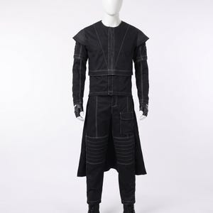 May include: A black long-sleeved jacket and matching trousers set featuring prominent white contrast stitching. The jacket has structured shoulders and a layered front, while the trousers include a side cargo pocket, knee panel detailing, and a rear skirt overlay.