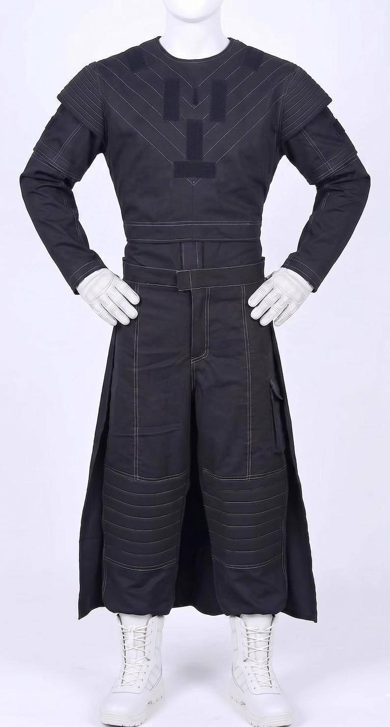 May include: A black long-sleeved top and matching trousers with white contrast stitching. The top features a V-shaped chest panel and shoulder detailing. The trousers include a belted waist, side pockets, and padded knee sections. White gloves and boots.