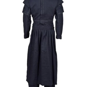 May include: A dark navy blue long-sleeved jacket and matching pleated skirt set. The jacket features structured shoulders with ribbed detailing, a vertical center seam, and white contrast stitching throughout the garment. The skirt is floor-length.