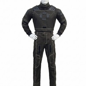 May include: A dark charcoal gray long-sleeved top and matching trousers set featuring white contrast stitching, a high collar, padded shoulder details, and rectangular black patches on the chest and thighs, displayed on a white mannequin.