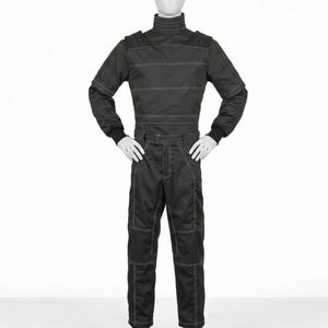 Pu&ograve; includere: Tuta da corsa nera con cuciture bianche. La tuta ha un collo alto, maniche lunghe e pantaloni aderenti. La tuta &egrave; esposta su un manichino. &Egrave; realizzata in materiale resistente.