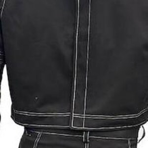 May include: A black jacket and matching trousers set featuring prominent white contrast stitching throughout. The jacket includes a high collar, a vertical center seam, and padded shoulder detailing. The trousers feature a structured fit.