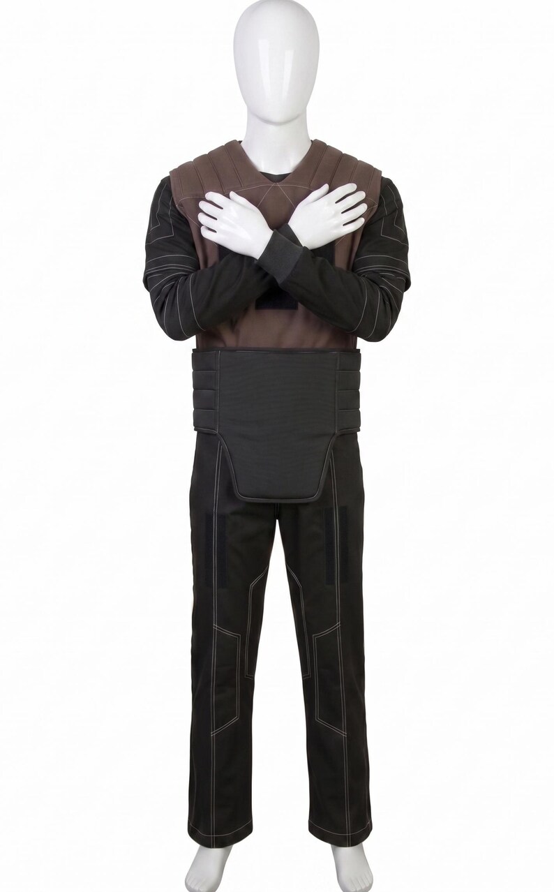May include: A full-body costume on a mannequin. The costume includes a brown vest, a black long-sleeved shirt, a black belt, and black trousers. White stitching accents the seams of the clothing. The mannequin's arms are crossed over its chest.