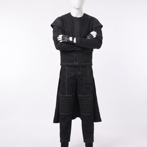 May include: A black long-sleeved jacket and matching trousers set featuring white contrast stitching, ribbed shoulder and knee panels, a flap pocket on the thigh, and a long back panel. The outfit includes black fingerless gloves and black boots.