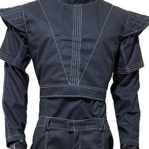 Pu&ograve; includere: Un completo composto da giacca a maniche lunghe e pantaloni blu scuro con evidenti cuciture bianche a contrasto. La giacca presenta spalline strutturate, un colletto alto e un design corto sul busto con linee verticali impunturate.