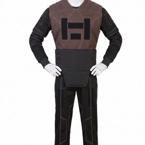 May include: A costume comprising a brown vest with a black rectangular design, a black belt, a black long-sleeved shirt, and black trousers with white stitching. The outfit is displayed on a mannequin.