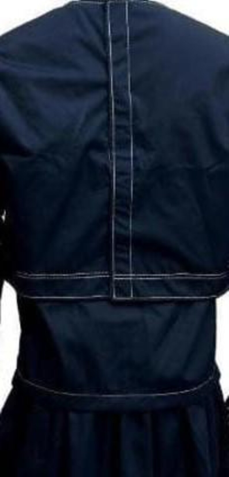 May include: A dark navy blue shirt featuring a vertical centre seam and a horizontal seam across the midsection, both accented with prominent white topstitching. The garment has a structured appearance with clean lines and a solid dark colour palette.