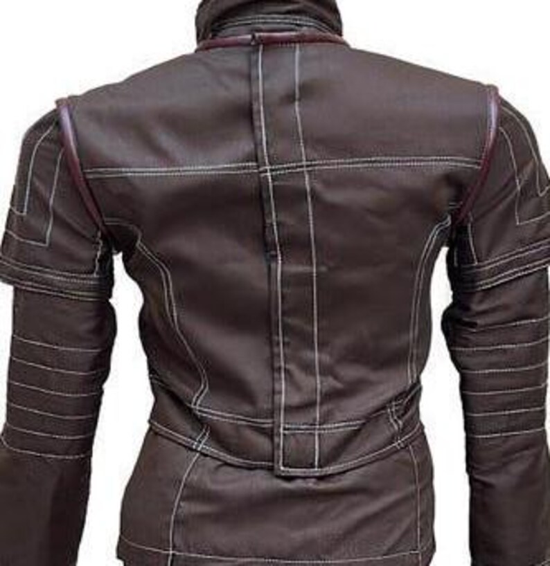 May include: A dark brown jacket featuring a high collar and long sleeves with ribbed detailing. The garment is constructed with prominent white contrast stitching throughout, including horizontal and vertical lines, and dark brown piping accents.
