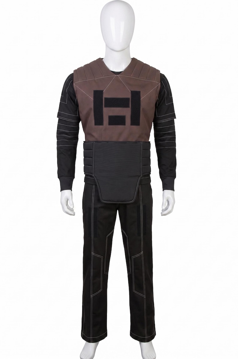 May include: A full costume on a mannequin. It features a brown vest with a black geometric design, a black long-sleeved shirt, black trousers, and a black belt. White stitching highlights the seams.