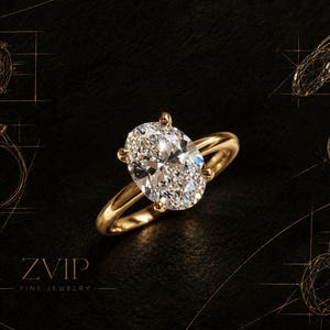 Puede incluir: Un anillo de oro con una gran piedra preciosa transparente de corte ovalado sujeta por cuatro garras. El fondo muestra dibujos técnicos del diseño del anillo y el texto ZVIP FINE JEWELRY en una fuente serif fina sobre una superficie oscura.