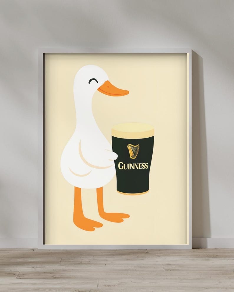 Puede incluir: Una impresi&oacute;n enmarcada con un pato de dibujos animados sosteniendo una pinta de Guinness. El pato es blanco con pico y patas naranjas. El vaso de Guinness es negro con espuma blanca y el logo de Guinness.