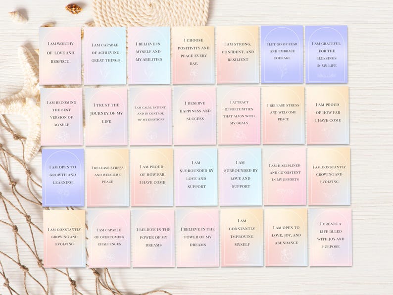 May include: A collection of affirmation cards with pastel backgrounds and inspirational phrases. Each card features a different positive statement, such as "I am worthy of love and respect." The cards are arranged on a neutral surface.