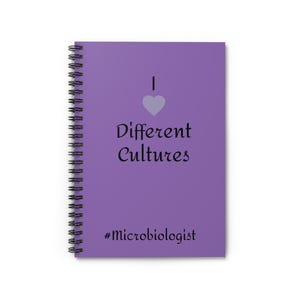 Könnte beinhalten: Ein lila Spiralnotizbuch. Auf dem Einband steht der Text "I ♥ Different Cultures" mit einem Herzsymbol und dem Hashtag "#Microbiologist". Das Notizbuch hat eine schwarze Spiralbindung.