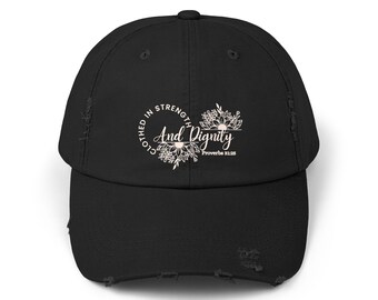 May include: Black distressed baseball cap with the text "Clothed in Strength And Dignity" in a white floral design. The cap has a curved brim and a distressed, worn look.