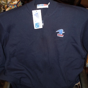 Op de afbeelding: Marineblauwe jas met ritssluiting en het U.S. Mail-logo op de borst geborduurd. De jas heeft een geribbelde kraag, manchetten en zoom. Een label met de merknaam is aan de rits bevestigd.