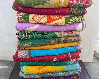 May include: A stack of colorful, patterned quilts. The quilts feature a variety of colors, including green, red, yellow, blue, and purple. The quilts are made of a soft material and are stacked on top of each other. The text "CRAFTSHIPINDIA" is visible.