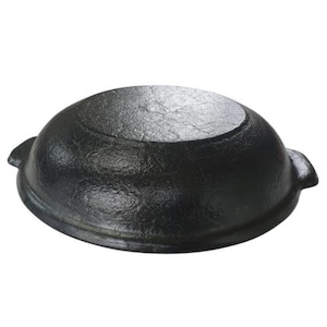 May include: A black cast iron pot with a rounded shape and two small handles on the sides. The pot has a textured surface and a flat bottom. This cookware is suitable for various cooking methods.