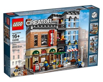 May include: A LEGO Creator Expert Detective's Office building set. The box shows a detailed three-story building with a brick facade, blue accents, and a barber shop. Includes 2262 pieces and is for ages 16+.
