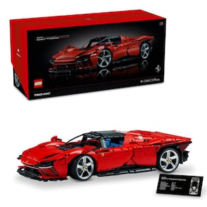 Puede incluir: Un coche modelo rojo LEGO Technic Ferrari Daytona SP3. El modelo se muestra junto a su caja roja, que presenta una imagen del coche. También hay una pequeña tarjeta negra con las especificaciones del coche.