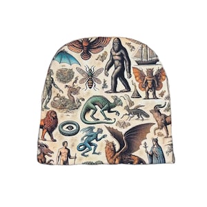 Puede incluir: Un gorro beige con un collage vintage de ilustraciones de criaturas míticas y animales. El diseño incluye un bigfoot, un dragón, un león, una abeja y un velero.