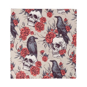 May include: A square textile featuring a repeating pattern of skulls, crows, and red roses on a light beige background. The skulls are white, the crows are dark gray, and the roses are a vibrant red. The design has a gothic or Halloween theme.