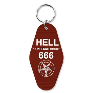 May include: A maroon-colored keychain with a silver ring. The keychain has the word "HELL" in white block letters, along with "13 INFERNO COURT" and the number "666". A white pentagram is also featured.