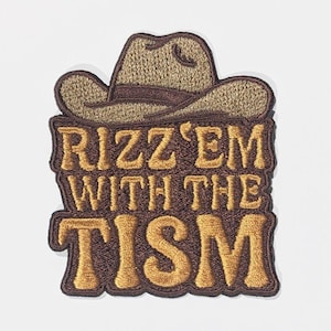 Peut inclure: Écusson brodé avec un chapeau de cowboy. Le patch présente le texte "RIZZ 'EM WITH THE TISM" en or, avec une bordure et un fond marron. Le chapeau de cowboy est marron et beige.