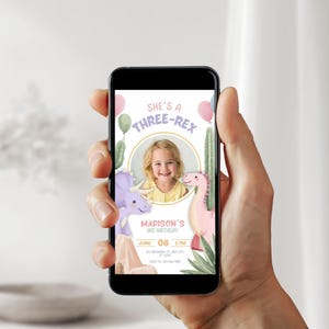 May include: A smartphone displays a birthday invitation with a child's photo. The design features a dinosaur theme with the text "She's a Three-Rex" and "Madison's 3rd Birthday". Pink and green balloons and cacti are also included.